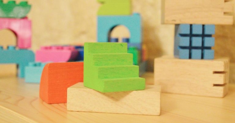 Green, orange, blue, pink and natural colored wooden blocks.