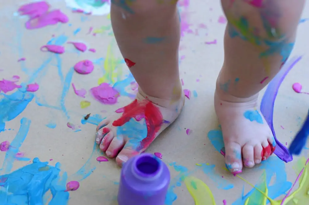 Finger Paint Smeared All Over The Floor And Young Toddlers Feet And Legs