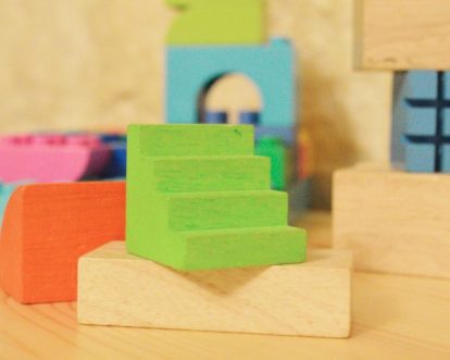 Green, orange, blue, pink and natural colored wooden blocks.